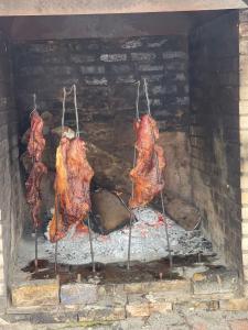 three pieces of meat cooking in a brick oven at Hotel Santo Lomo in La Vega