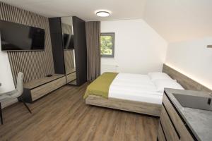 una habitación de hotel con una cama y un lavabo en 4 Elements Resort Bled, en Bohinjska Bela