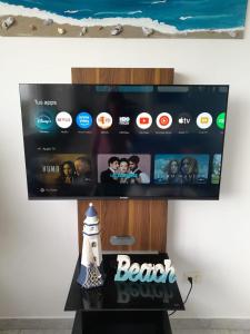 a television screen with a beach show on a table at Apartamento con vista al mar in Pampatar +30 photos