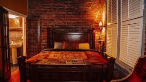 Un dormitorio con una cama y una pared de ladrillo. en Printers Alley Downtown Mansion, en Nashville 79 fotos más