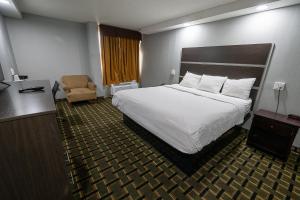 a hotel room with a bed and a chair at Days Hotel by Wyndham Danville Conference Center in Danville +21 photos