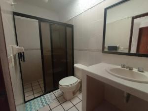 a bathroom with a shower and a toilet and a sink at Casa Luna in Barra de Navidad
