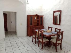 a dining room with a table and chairs and a mirror at Casa Luna in Barra de Navidad