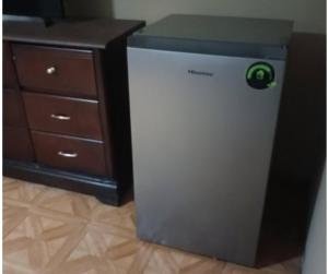 a small refrigerator sitting next to a desk at cuarto acogedor y privado para descansar in Monterrey