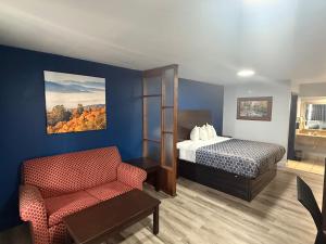 a hotel room with a bed and a chair at Galaxy Inn & Suites in Little Rock +20 photos