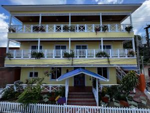 a yellow house with a white fence in front of it at The Winand Hotel in Lívingston