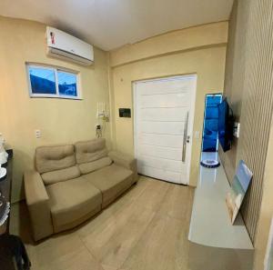 a living room with a couch and a door at Apartamento refúgio in Flecheiras