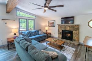 a living room with a blue couch and a fireplace at Walk to Lake Family Home with Game Room, Deck and BBQ in Lake Harmony