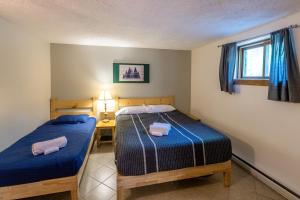 a bedroom with two beds and a desk and a window at Walk to Lake Family Home with Game Room, Deck and BBQ in Lake Harmony