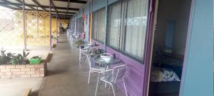 a row of tables and chairs on the side of a building at Reef Gardens Motel in Proserpine