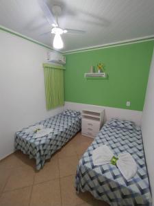 two beds in a room with green walls at Kayc pousada in Amargosa
