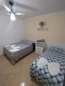 a bedroom with two beds and a ceiling fan at Kayc pousada in Amargosa