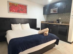a bedroom with a large bed and a kitchen at Casa Balam Gladiolas in Cancún