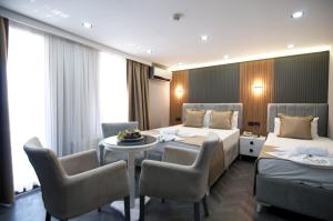 Una habitación de hotel con dos camas y una mesa y sillas. en Grand Bagoz Hotel, en Estambul
