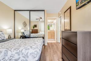 a bedroom with a bed and a dresser with a mirror at Lively 2Bd 2Bth condo AC 5 min walk to beach in Lahaina +5 photos