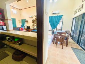a kitchen and dining room with a table and chairs at The 5R Famosa Villa in Kampong Ulu Pegoh