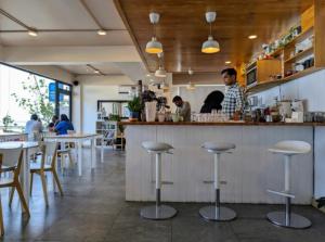 a man standing at a counter in a restaurant at Nala Host- Seaside Bliss in Hulhumale