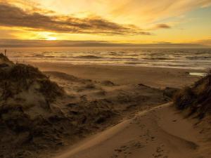 een zandstrand met de oceaan en een zonsondergang bij 6 person holiday home in Ringkøbing in Ringkøbing