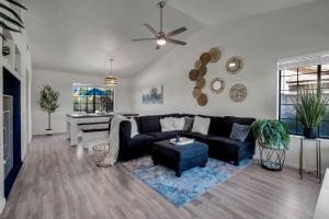 a living room with a black couch and a table at Azure Oasis-Saltwater Pool & Spa with Putting green! in Palm Desert