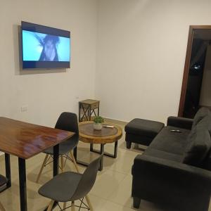 a living room with a couch and a tv on a wall at Departamento Casa Bahía in Nuevo Vallarta 