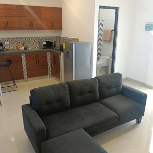 a living room with a couch and a kitchen at Departamento Casa Bahía in Nuevo Vallarta 