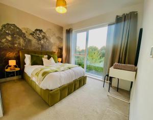 a bedroom with a bed and a large window at Superb House Sleeps 7 parking in Cambridge in Trumpington
