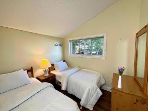 Una habitación de hotel con dos camas y una ventana. en 2-Bedroom Cottage #11 - Ambleside, en Kawartha Lakes