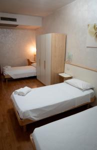 a hotel room with two beds and a cabinet at Hotel La Coccinella in Lavello