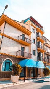 a building with blue umbrellas in front of it at Hotel La Coccinella in Lavello