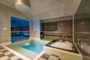 a large bathroom with a bath tub with a swimming pool at Spa urbano Motel Adult Only in Fortaleza