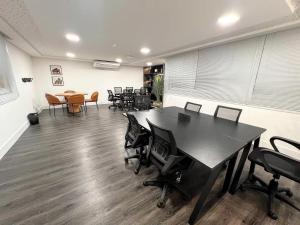 イタパリカにある2Q moderno c/ Piscina e Academiaの黒いテーブルと椅子とテーブルのあるオフィス +23枚の写真