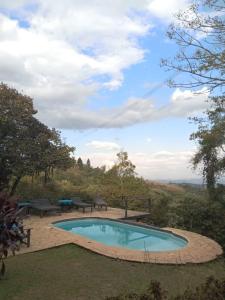 a swimming pool with a picnic table and benches around it at Espaço Casa Mato in Taubaté