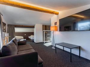 una sala de estar con un sofá y una mesa en Chalet H XL, en Königsleiten