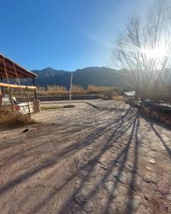 a dirt road with the shadows of trees on it at Della monica in Tinogasta
