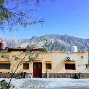 a building with mountains in the background at Della monica in Tinogasta
