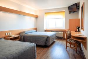 Una habitación de hotel con dos camas y un escritorio. en Intercity Zapopan, en Guadalajara 14 fotos más