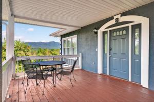 a porch with a table and chairs on a deck at Whitepath Lodge and Resort in Ellijay