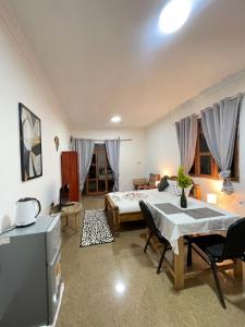 a living room with a bed and a table and chairs at Zanzllywood Uroa Beach Suites Hotel Apartment in Dikoni +12 photos