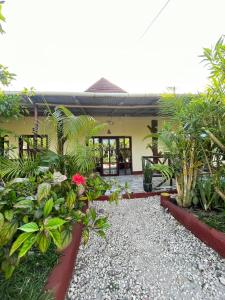 a garden in front of a house with plants at Zanzllywood Uroa Beach Suites Hotel Apartment in Dikoni