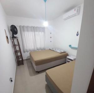 a small room with a bed and a window at Casa com piscina! Descanso e Lazer in Itapoa +19 photos