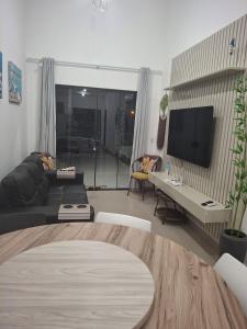 a living room with a couch and a flat screen tv at Casa com piscina! Descanso e Lazer in Itapoa