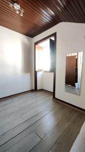 フィゲイラ・ダ・フォズにあるPrivate Room 202 in Guest House da Fonteの大きな鏡が備わるウッドフロアの空き部屋 +8枚の写真