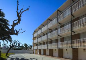 Una vista exterior de un edificio de apartamentos con árboles. en Sinia apartment, en Cambrils