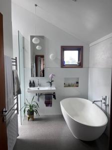 a white bathroom with a tub and a sink at Nelson - architect designed oasis Port Melbourne in Melbourne
