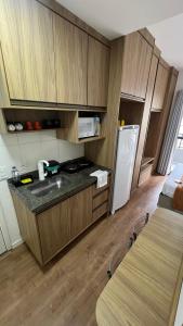 a small kitchen with a sink and a refrigerator at Studio 604 - Seu refúgio Urbano no Coração de São Paulo - Wifi, Vaga, Academia, Lavanderia, Mercado e Rooftop in Sao Paulo