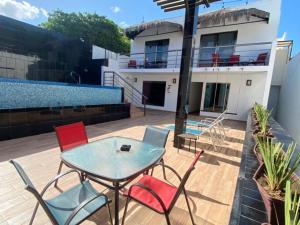 a patio with a table and chairs and a house at Casa Balam Gladiolas in Cancún