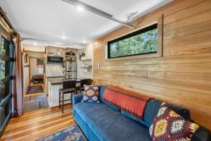 a living room with a blue couch and a window at Two Pines - Unique container home w/hot tub - Downtown - Trailer Parking - Pet friendly in McCall