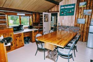 a dining room with a wooden table and chairs at Country Rustic Loghouse at Teepee Meadows in Valemount