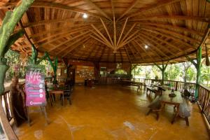 a large room with tables and chairs and a wooden ceiling at Hotel Ecologico Makalombia in La Macarena