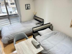 a room with two beds and a table and a chair at Bliss金池 in Oita